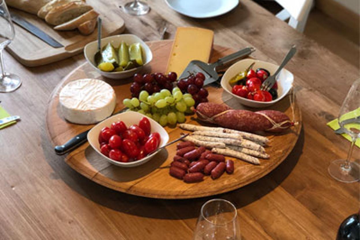 Rustikales Käsebrett aus Holz mit Snacks und Wein
