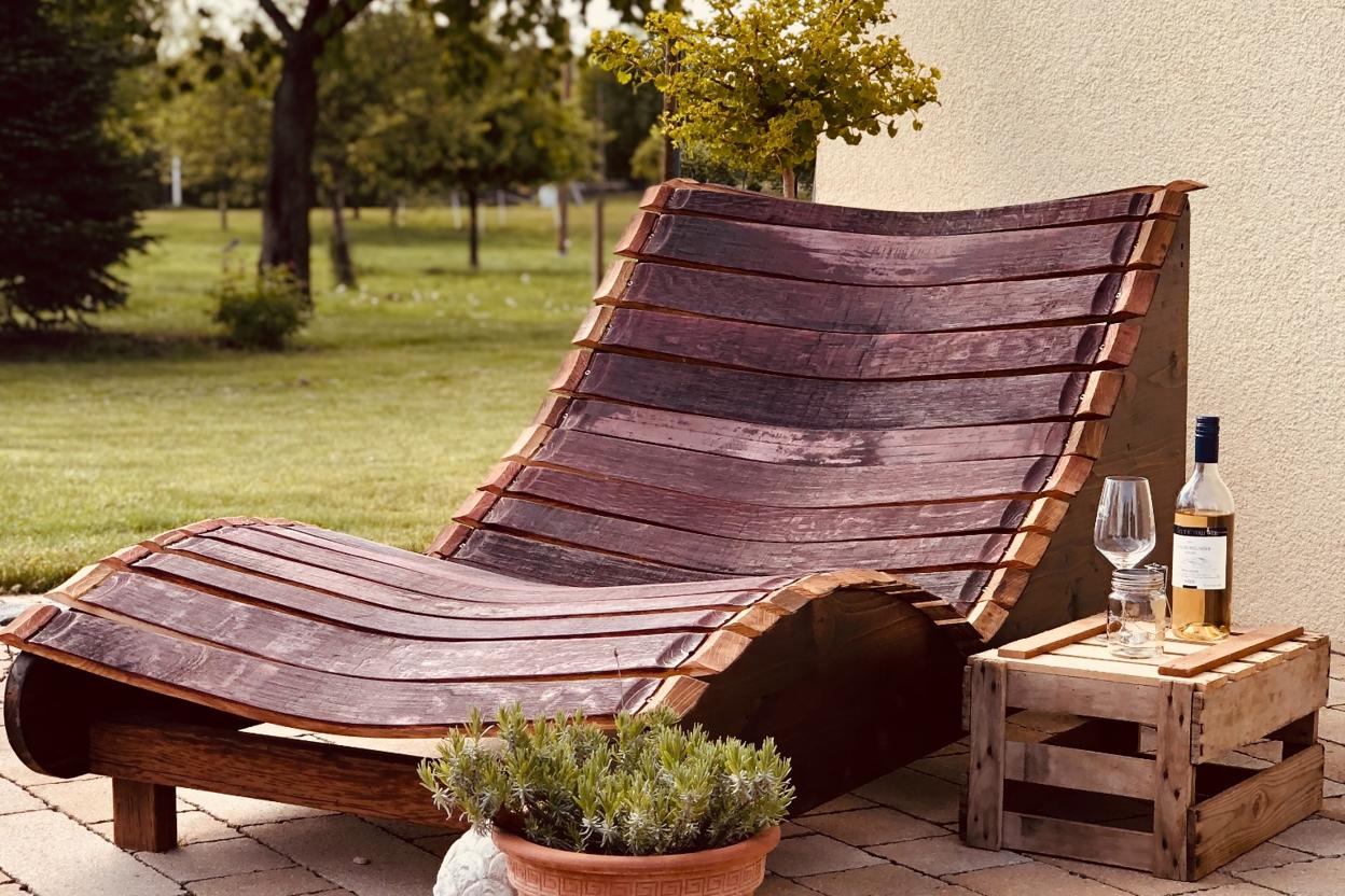 Geschwungene Gartenliege aus Holz im Gartenbereich