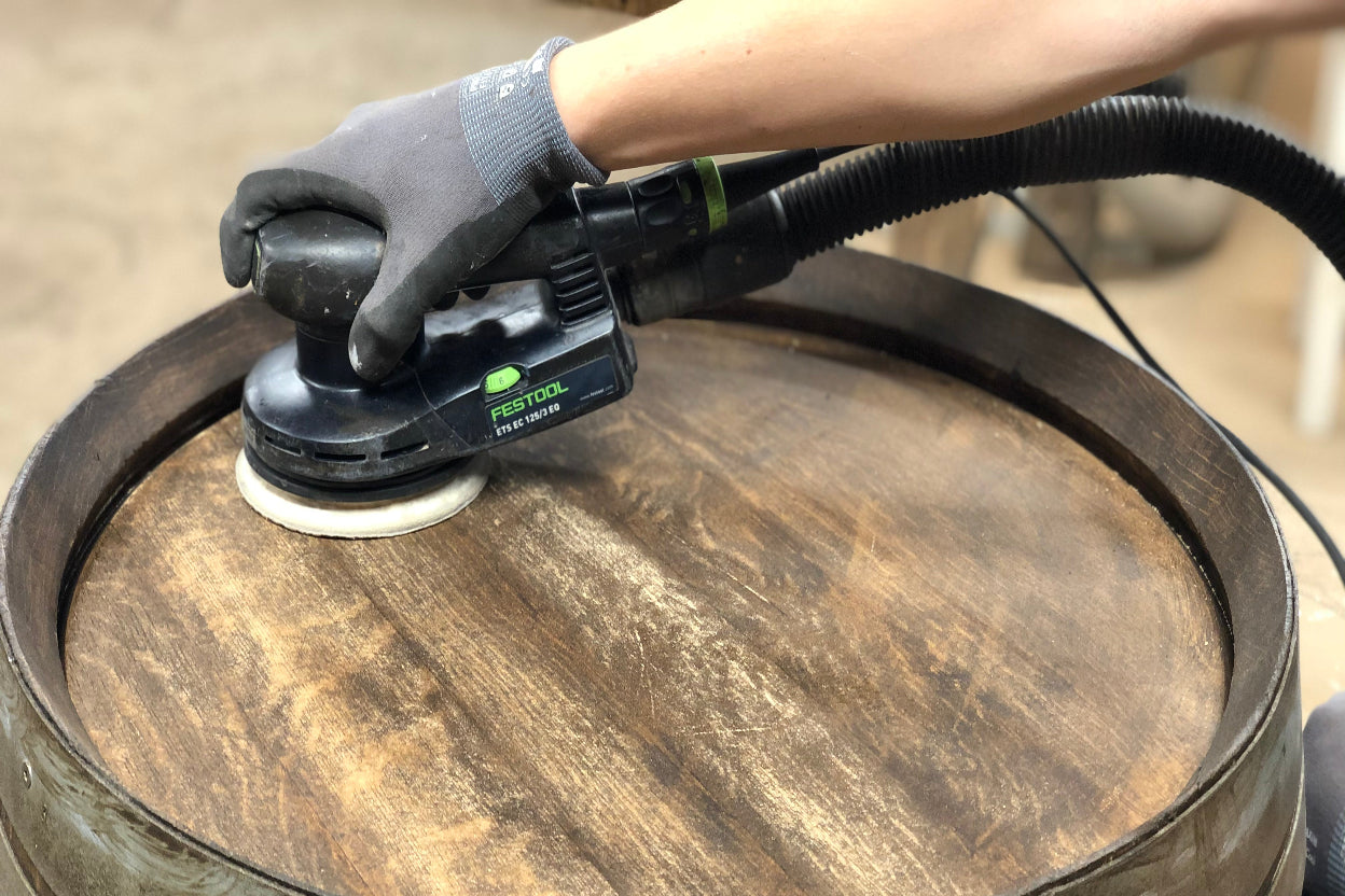 Bearbeitung eines Weinfasses in Handarbeit in der Werkstatt