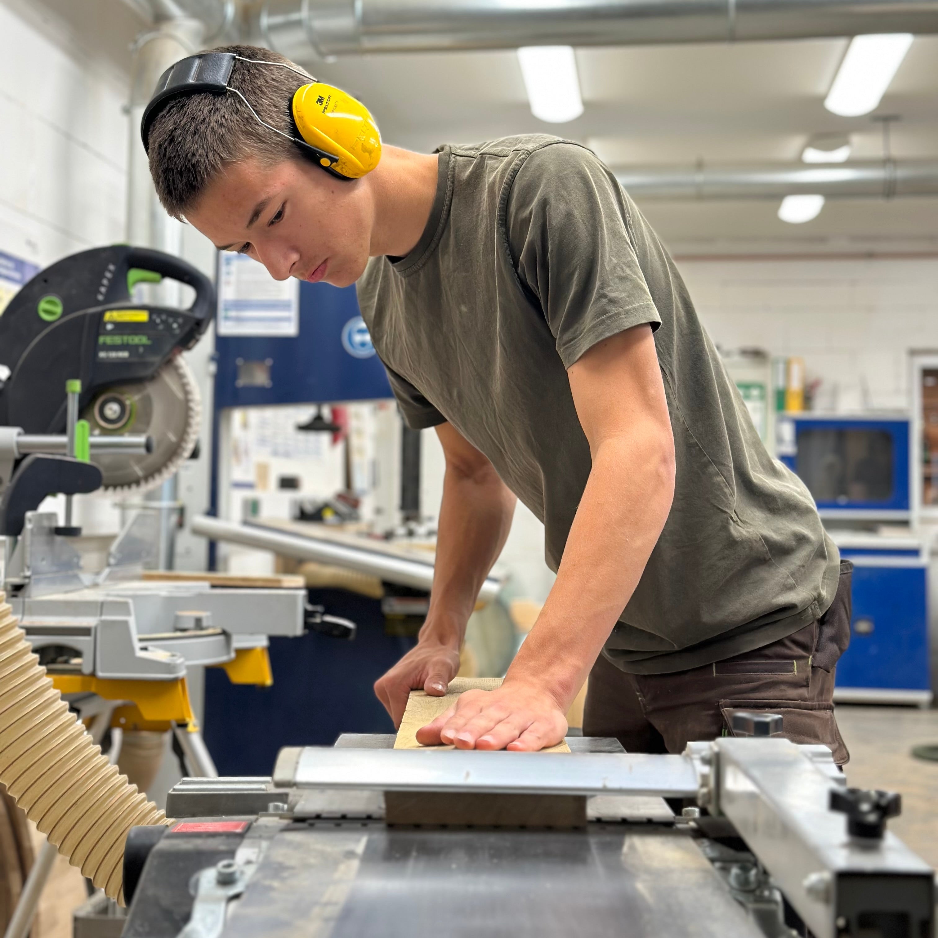 Tim bei der Holzbearbeitung in der Werkstatt der Fass-Schmiede