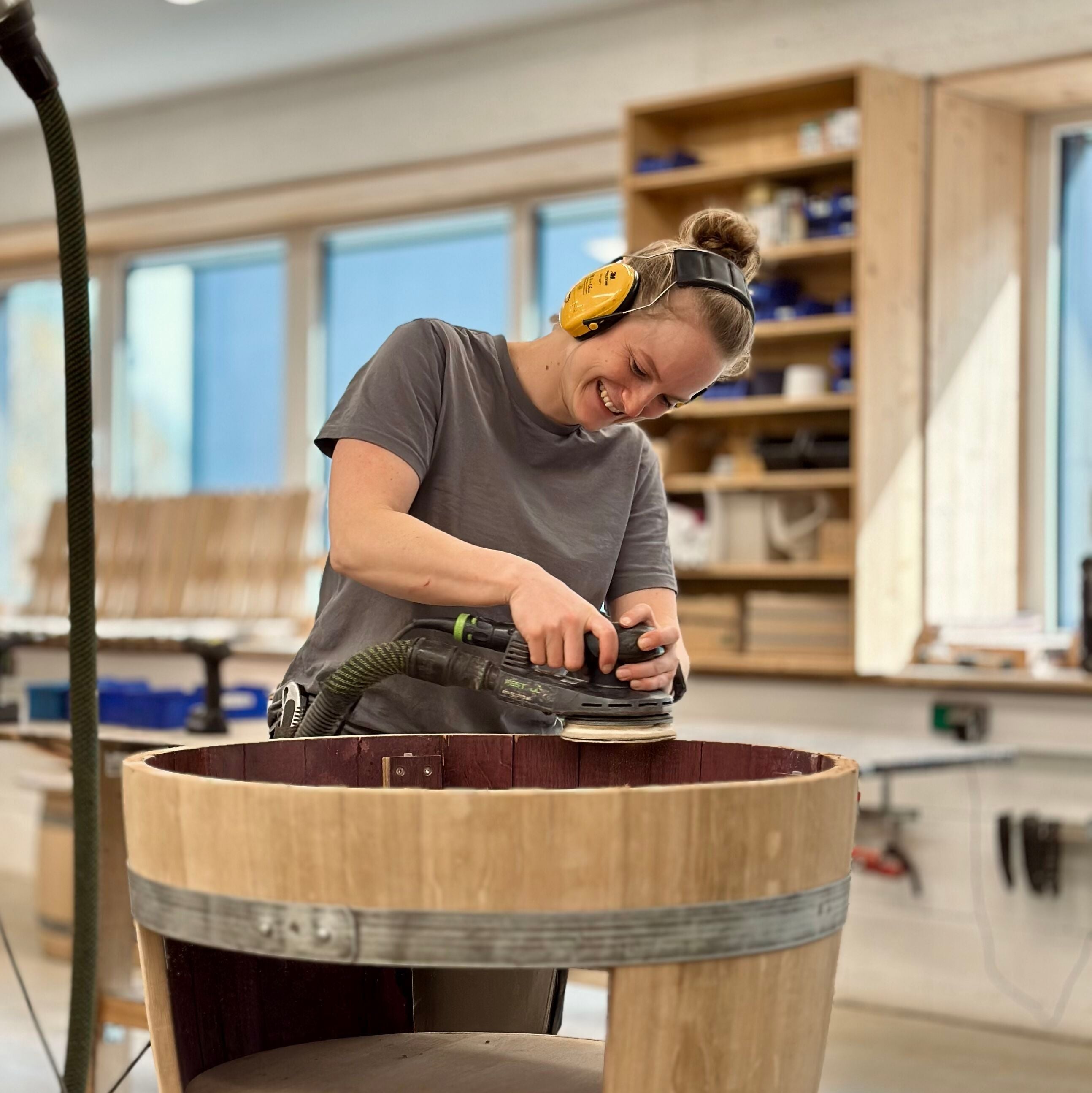 Annika bei der handwerklichen Bearbeitung eines Fassmöbels
